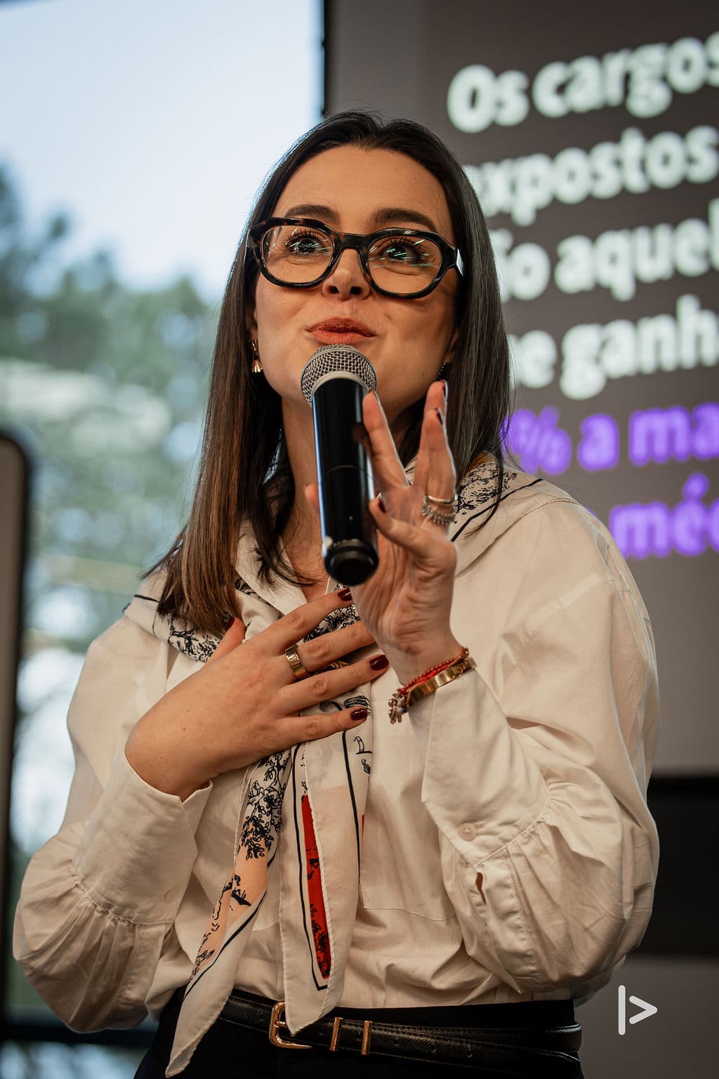 Izabela Anholett falando ao microfone durante um treinamento corporativo